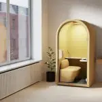 Interior of ARC Pod phone booth with ergonomic desk, acoustic felt walls, and designer LED lighting